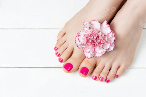 Preview: Pink pedicure with a flower on white wooden background, top view, copy space