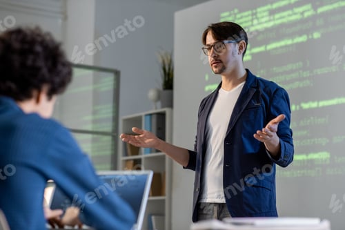 Preview: Young teacher or coach in casualwear and eyeglasses explaining main points