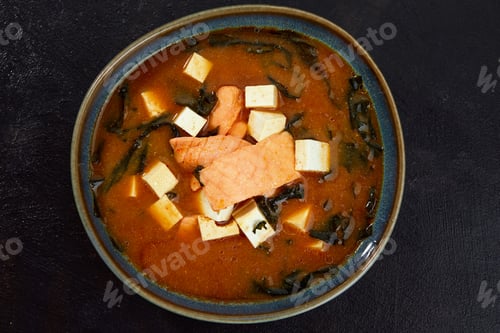 Preview: Japanese miso soup in a gray bowl on the black table. horizontal view from above