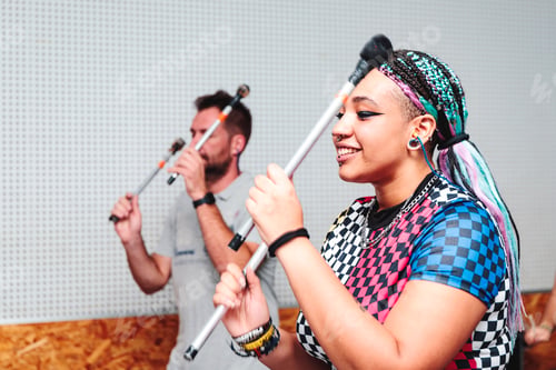 Preview: man and woman with drumsticks in hand with the intention of playing