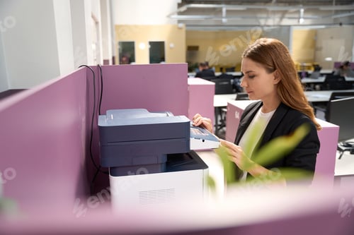 Preview: Female standing near the printer in the business center