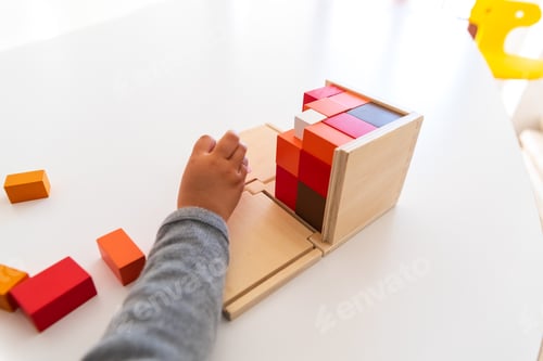 Preview: Montessori student hands using sensory materials in a school.