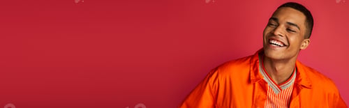Preview: excited african american guy laughing on red background, orange shirt, portrait, banner, copy space