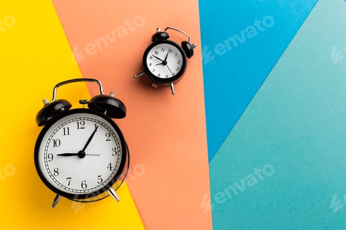 Preview: Vintage black alarm clock on a color block background