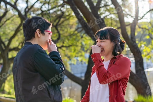 Preview: LGBT couple of women sharing a playful, knowing laugh while looking at each other