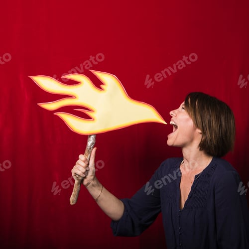 Preview: Woman holding cardboard cut-out of flames pretending to breathe fire