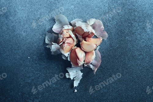 Preview: Overhead View of Garlic Cloves on Textured Blue Surface.