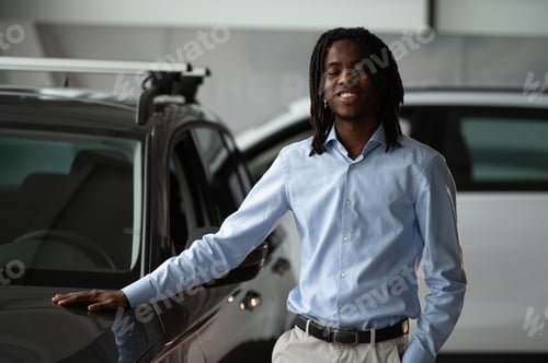 Preview: Front view. Car seller, businessman is standing in automobile salon