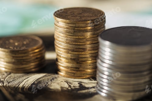 Preview: selective focus of ukrainian coins stacks on dollar banknote with blurred background