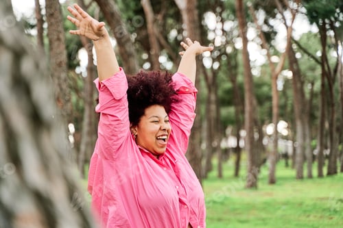 Preview: curvy woman with curls taking fresh air in nature.