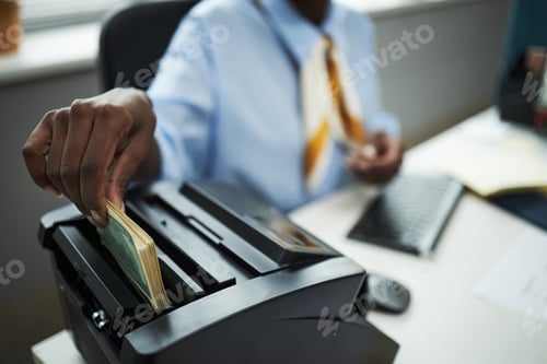 Preview: Hand of Bank Worker Counting Cash with Bill Counter in Office
