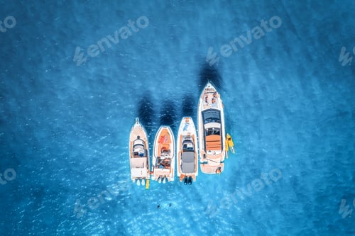 Preview: Aerial view of luxury yachts and boats on blue sea at sunrise