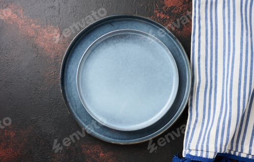 Preview: Round blue ceramic empty plates and kitchen towel, top view