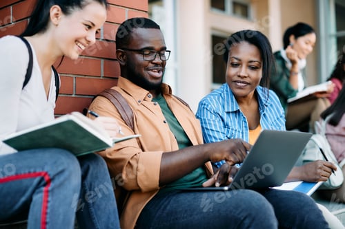 Preview: Multiracial group of college friends e-learning on laptop at campus.