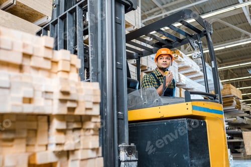 Preview: selective focus of indian warehouse worker sitting in forklift machine