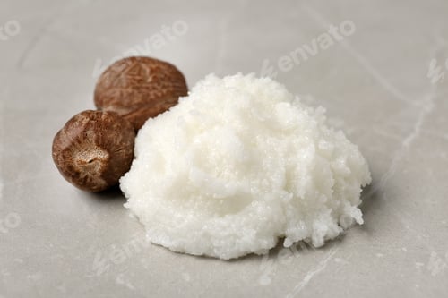 Preview: Shea butter and nuts on grey background, closeup