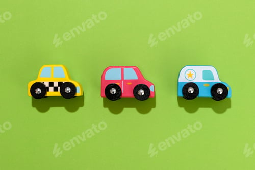 Preview: Three colorful wooden toy cars on green background