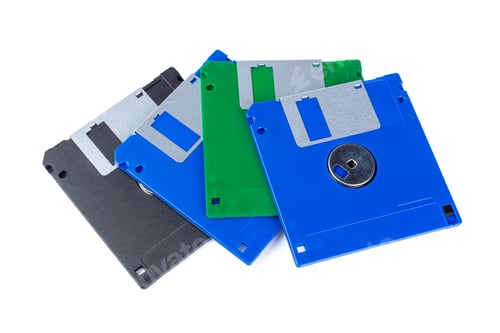 Preview: Old computer disks in different colors on a white background for storage purposes