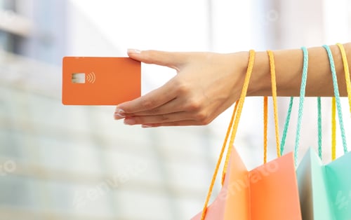 Preview: Young caucasian woman with many shopping bags showing credit card in hand, enjoy walk, shopping