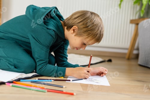 Preview: Boy drawing in on the floor a cozy room.