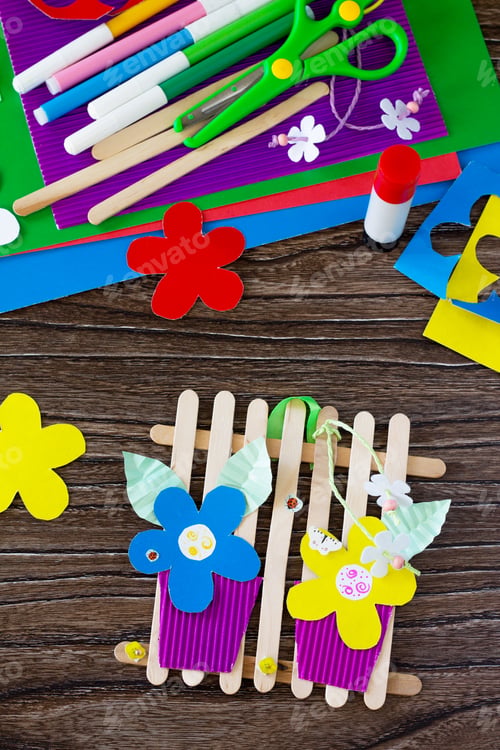 Preview: A gift of summer flowers on wooden sticks a fence on a wooden table.