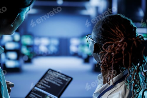 Preview: Coworkers code on tablet in data center