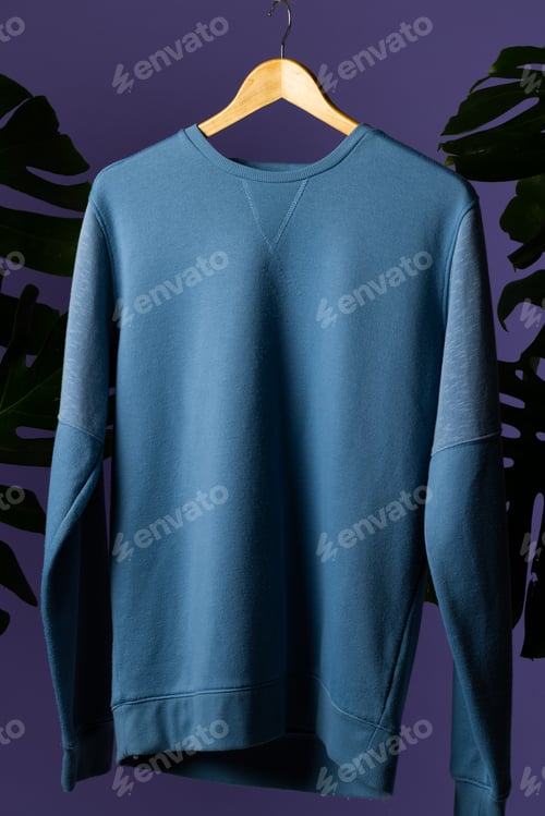 Preview: Sweatshirt hanging on coat hanger and copy space on purple background