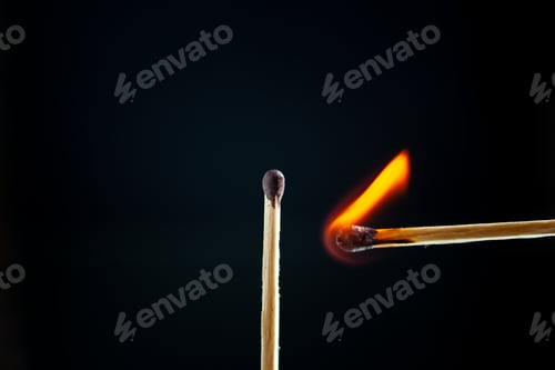 Preview: Above view of lighting one match to another one on dark background