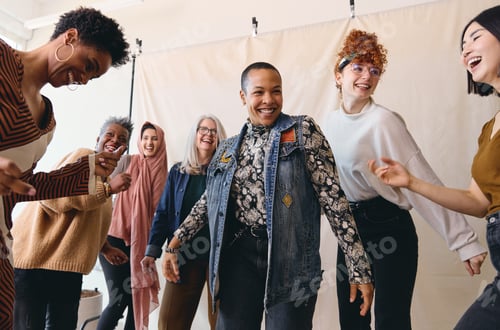 Preview: International Women's Day candid portrait of multi ethnic mixed age range women dancing
