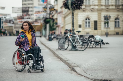 Preview: Woman with disability using a smartphone while out in the city