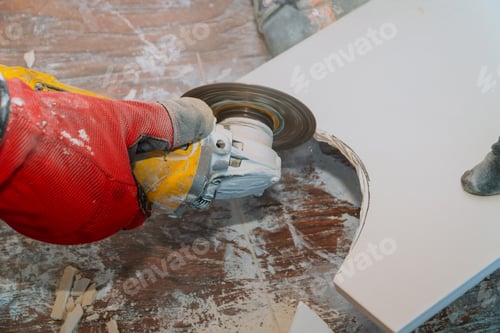 Preview: Man professional worker cutting tile with circular saw electric on renovation bathroom
