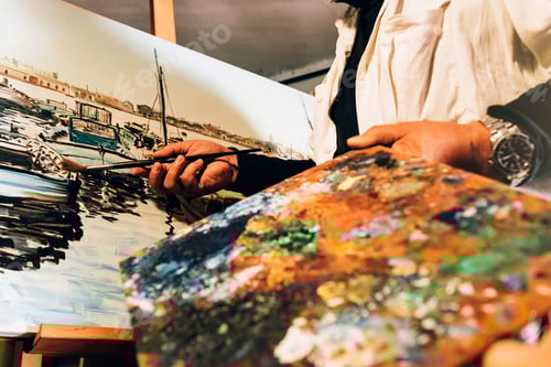 Preview: Close up of man artist painting oils in his studio.