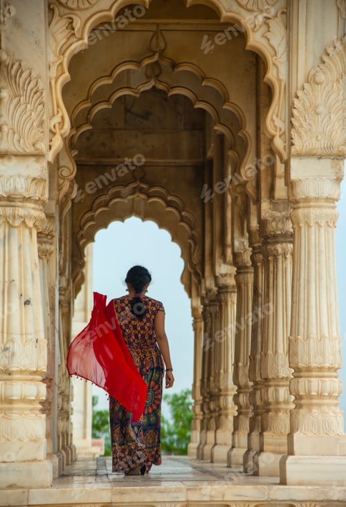 Preview: Young female tourist dancing between arches and Pillars.