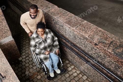 Preview: Black Couple with Man in Wheelchair using Ramp in City