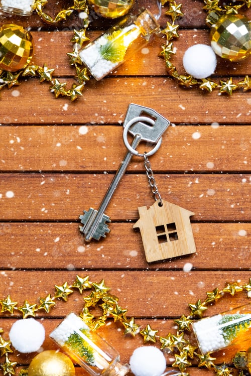 Preview: Key to house with a keychain tiny home on wooden background with Christmas decor layout. Gift for Ne