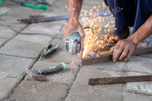 Preview: Person cutting metal bars with an angle grinder