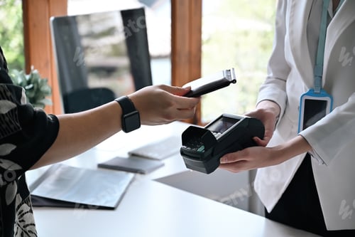 Preview: Cropped image of customer using smart phone scanning for contactless payment.