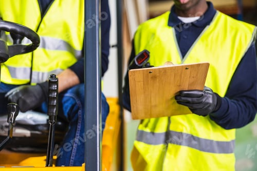 Preview: Warehouse worker scanning product on clipboard with colleague