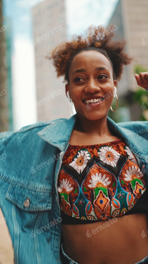 Preview: Closeup, smiling African listening to music on headphones and dancing outdoors.