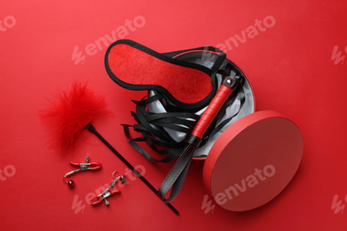 Preview: Gift box with different sex toys on red background, flat lay