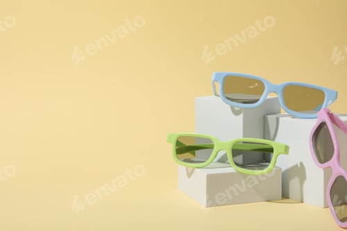 Preview: Colorful sunglasses on white blocks on beige background, space for text