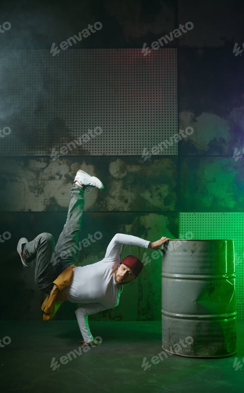 Preview: Male break dancer performing on loft stage in green neon light