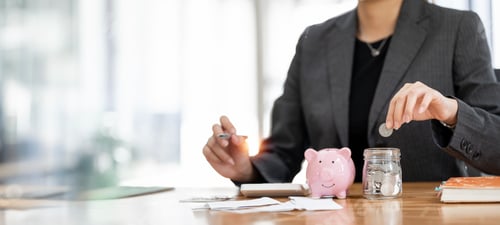 Preview: Woman Saving Money in Piggy Bank at Workplace