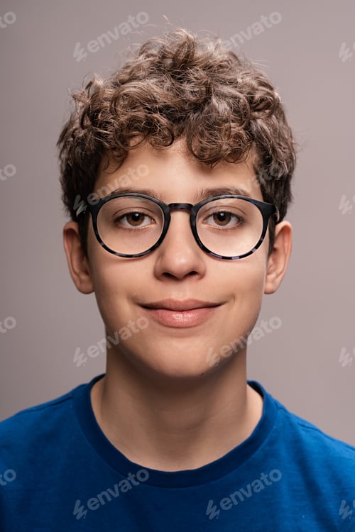 Preview: Teenage boy with glasses portrait - Young male smiling headshot: Happy adolescent with curly hair