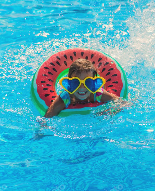 Preview: The child in the pool swims in a circle. Selective focus.