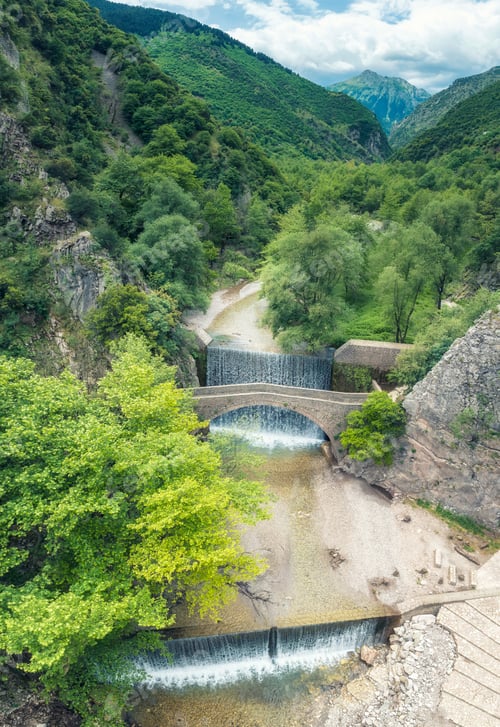 Preview: Aerial view of a picturesque old stone arch bridge at beautiful waterfall