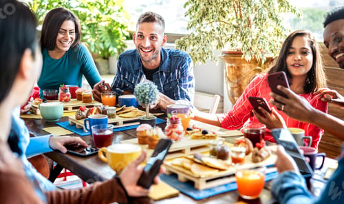 Preview: Multiracial friends interacting with mobile phone at coffee bar