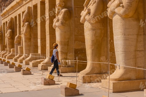 Preview: A young woman with pharaoh sculptures entering Hatshepsut's Funerary Temple in Luxor. Egypt