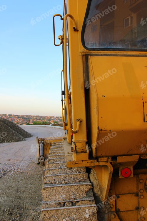 Preview: Vertical back view of yellow excavator at a construction site