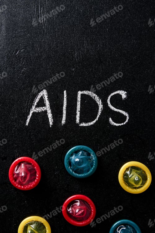 Preview: top view of aids sign with multicolored condoms on black background
